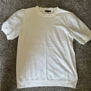 White shirt. Eyelet sleeves.